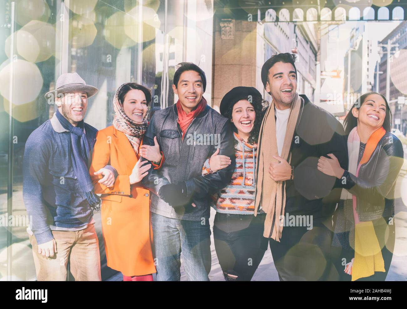 Un gruppo di giovani amici a piedi in città durante la stagione invernale e preinstallato in un abbigliamento caldo - Divertirsi sorridenti - illuminazione Bokeh di fondo Foto Stock