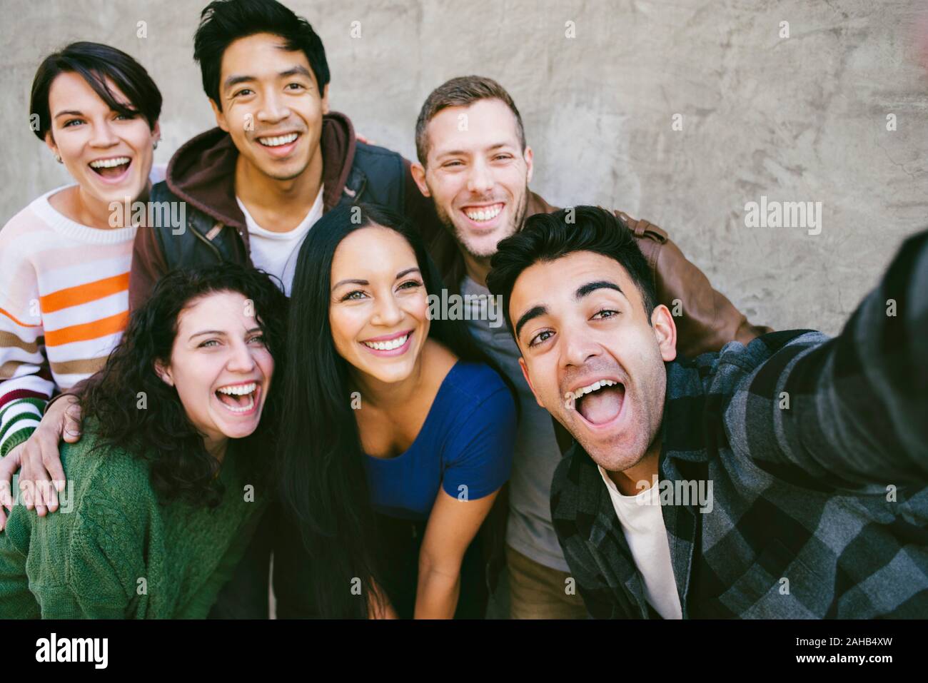 Il gruppo di amici si radunano per catturare un selfie con espressioni felici Foto Stock