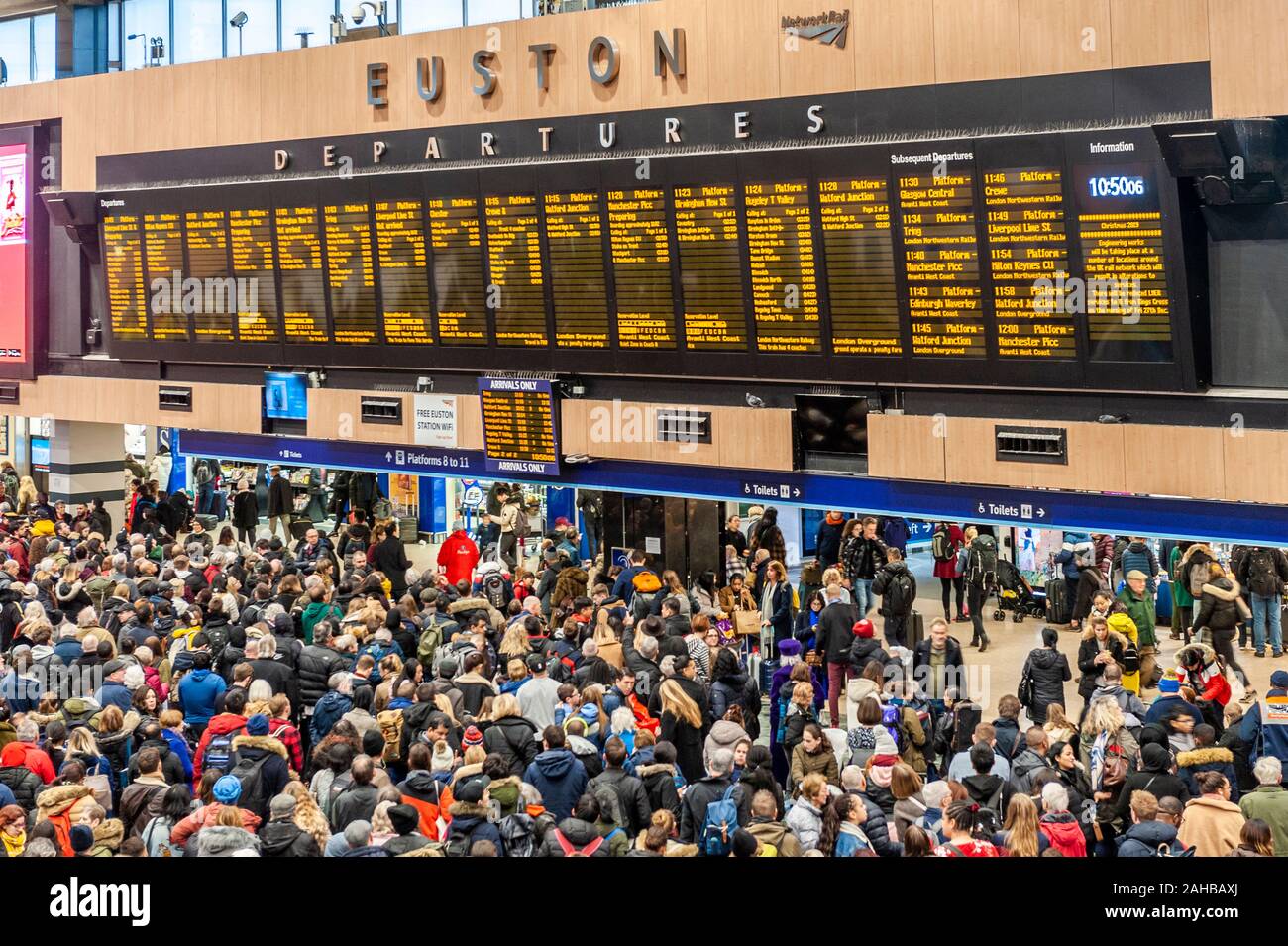 Folle immense a Londra la stazione di Euston concourse guardando le schede di partenza. Londra, Inghilterra. Foto Stock
