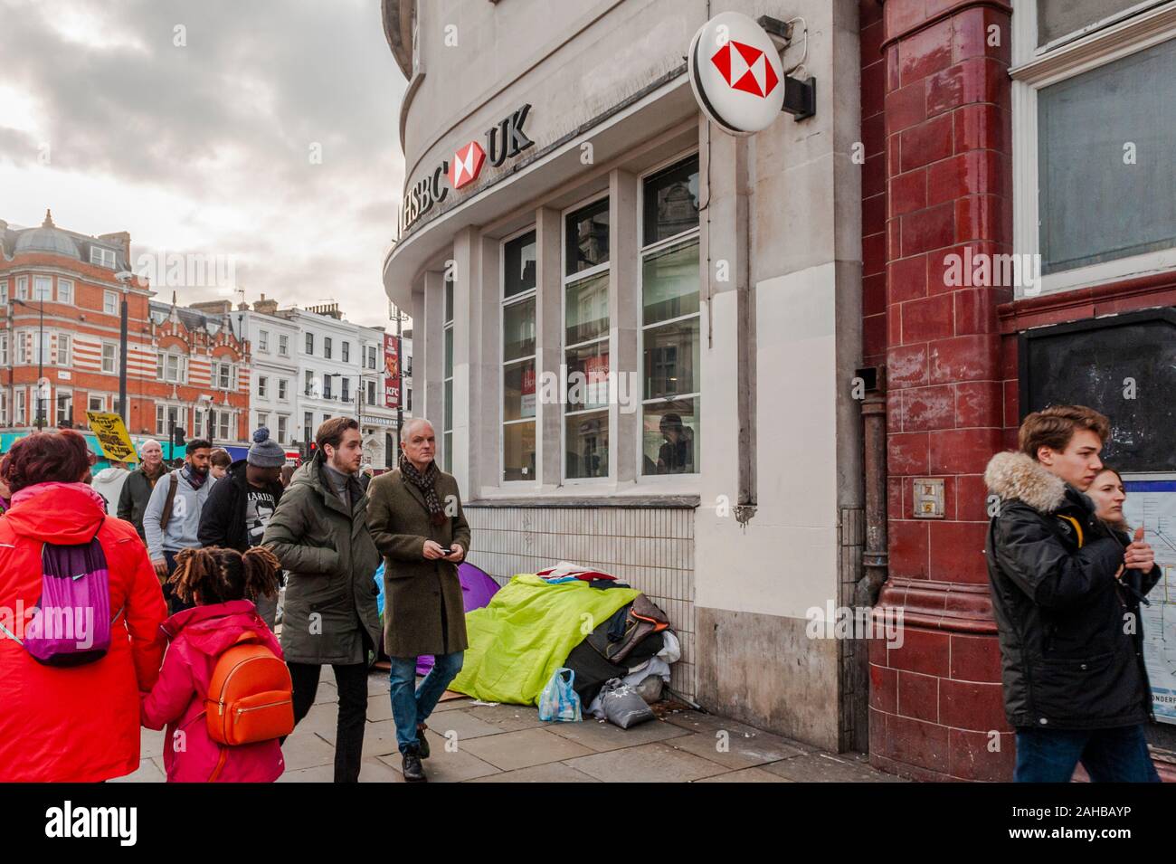 La gente passa una persona senza dimora della tenda di fortuna al di fuori di HSBC Bank di Londra, Regno Unito. Foto Stock