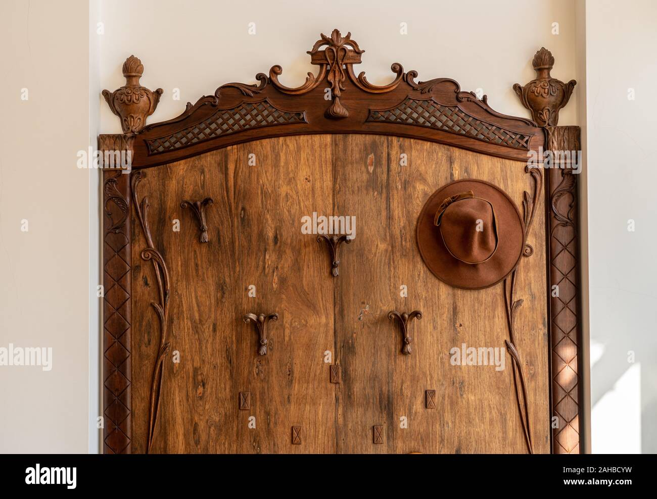 Vecchio cappello in legno, rivestimento e portaombrelli in corridoio sul pavimento di marmo Foto Stock