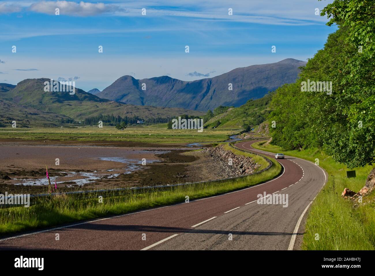Classic Lotus guidando lungo una strada tortuosa accanto al fiume Kishorn, con Beinn Damh in background Foto Stock
