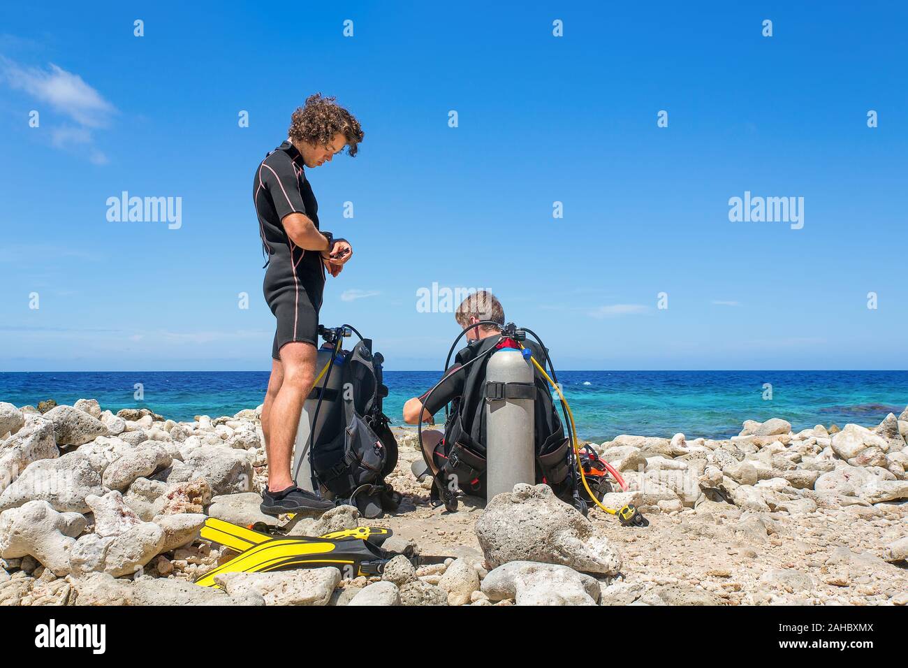 Due giovani tuffatori olandese sulla spiaggia la preparazione per un tuffo a Bonaire Foto Stock