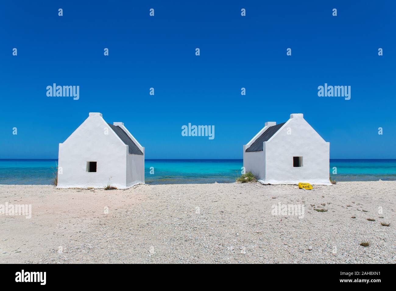 Due slave bianco case sulla spiaggia con mare blu sulla isola di Bonaire Foto Stock