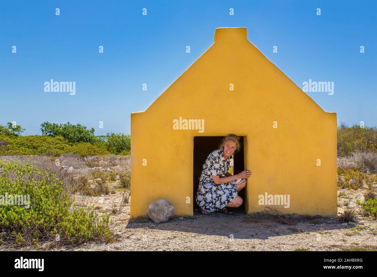 Donna olandese entrando in giallo casa slave presso la spiaggia di Bonaire Foto Stock