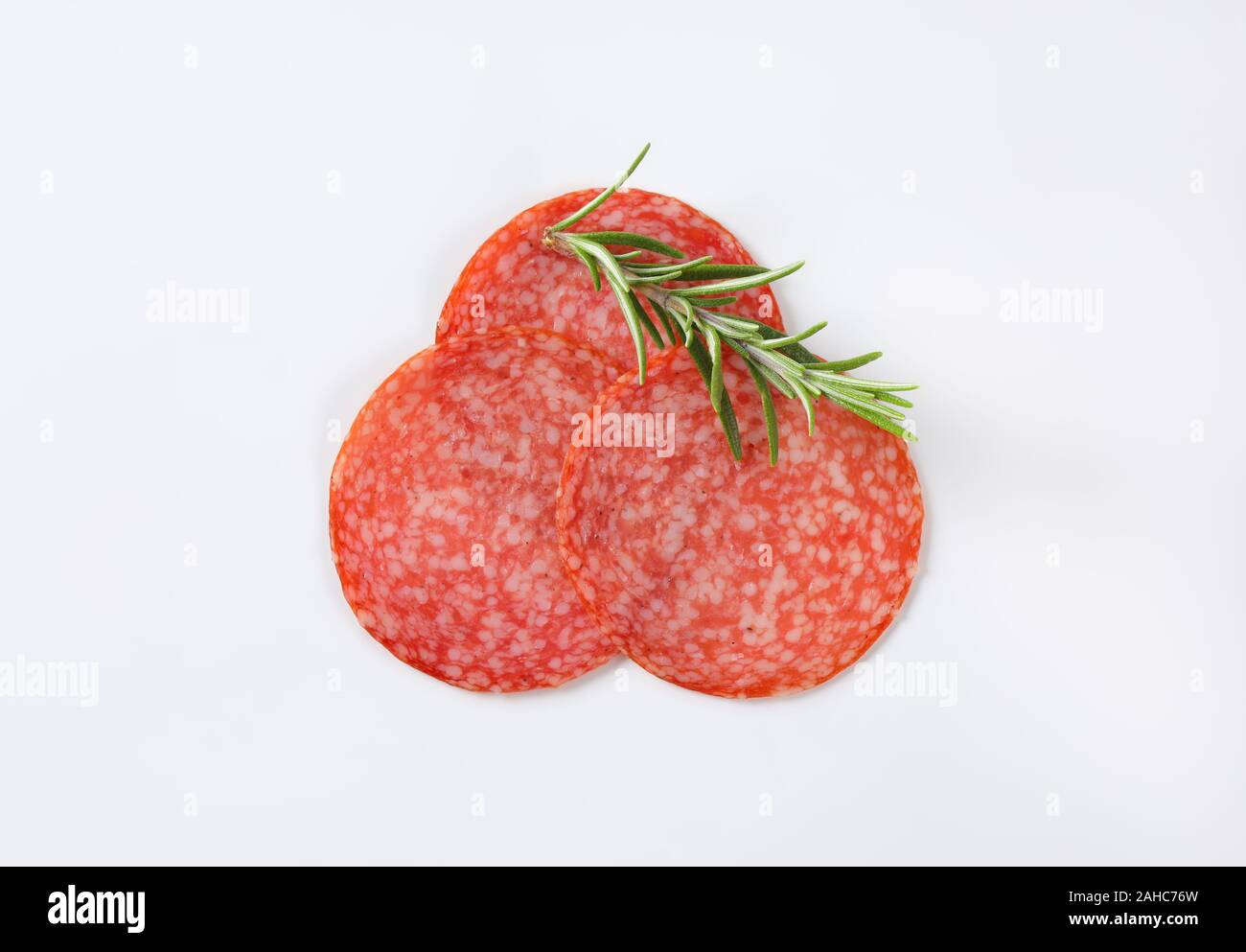 Sottili fette di salame ungherese e di rosmarino fresco Foto Stock