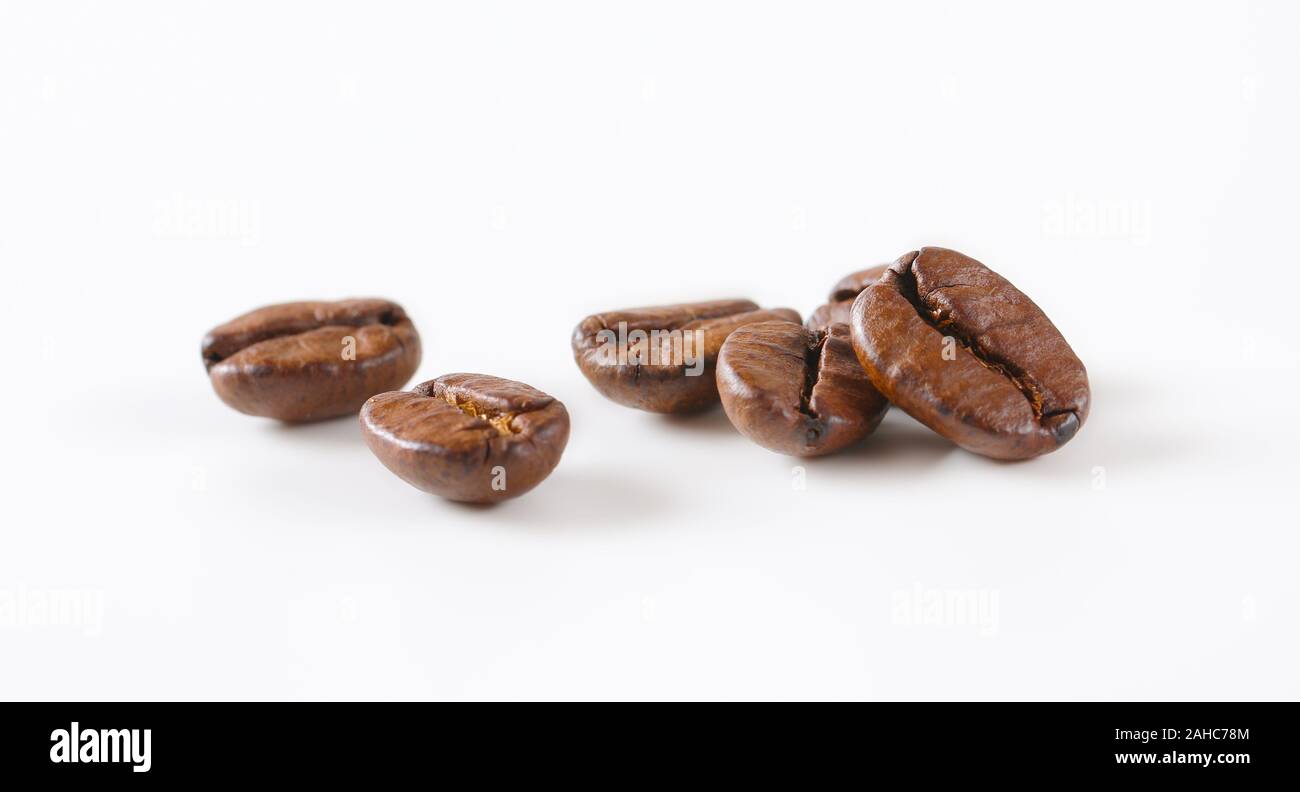 Chicchi di caffè tostati su sfondo bianco Foto Stock