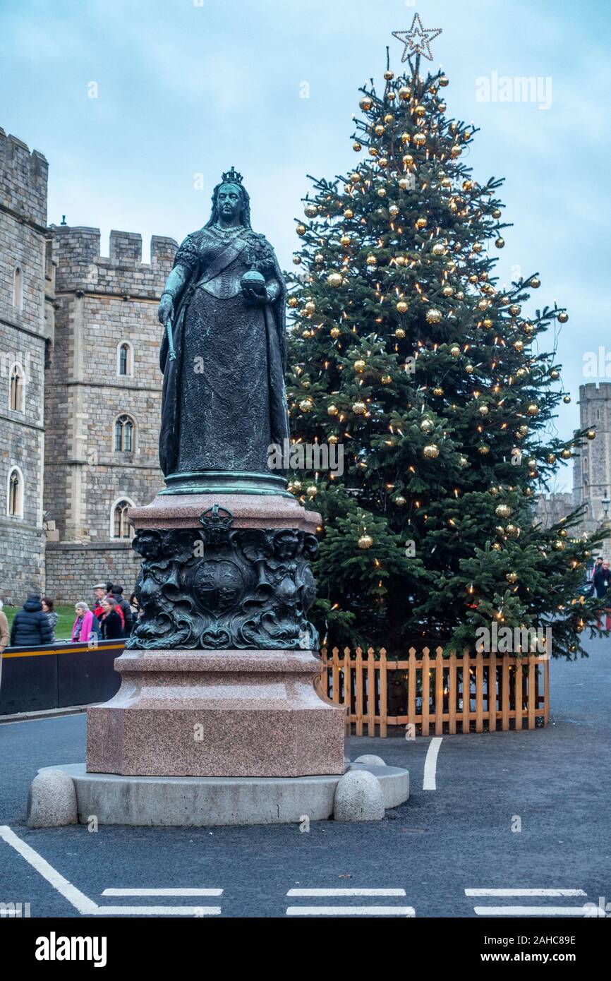 Statua di bronzo di Queen Victoria sorge al di fuori del Castello di Windsor in Inghilterra con un albero di Natale dietro, Foto Stock