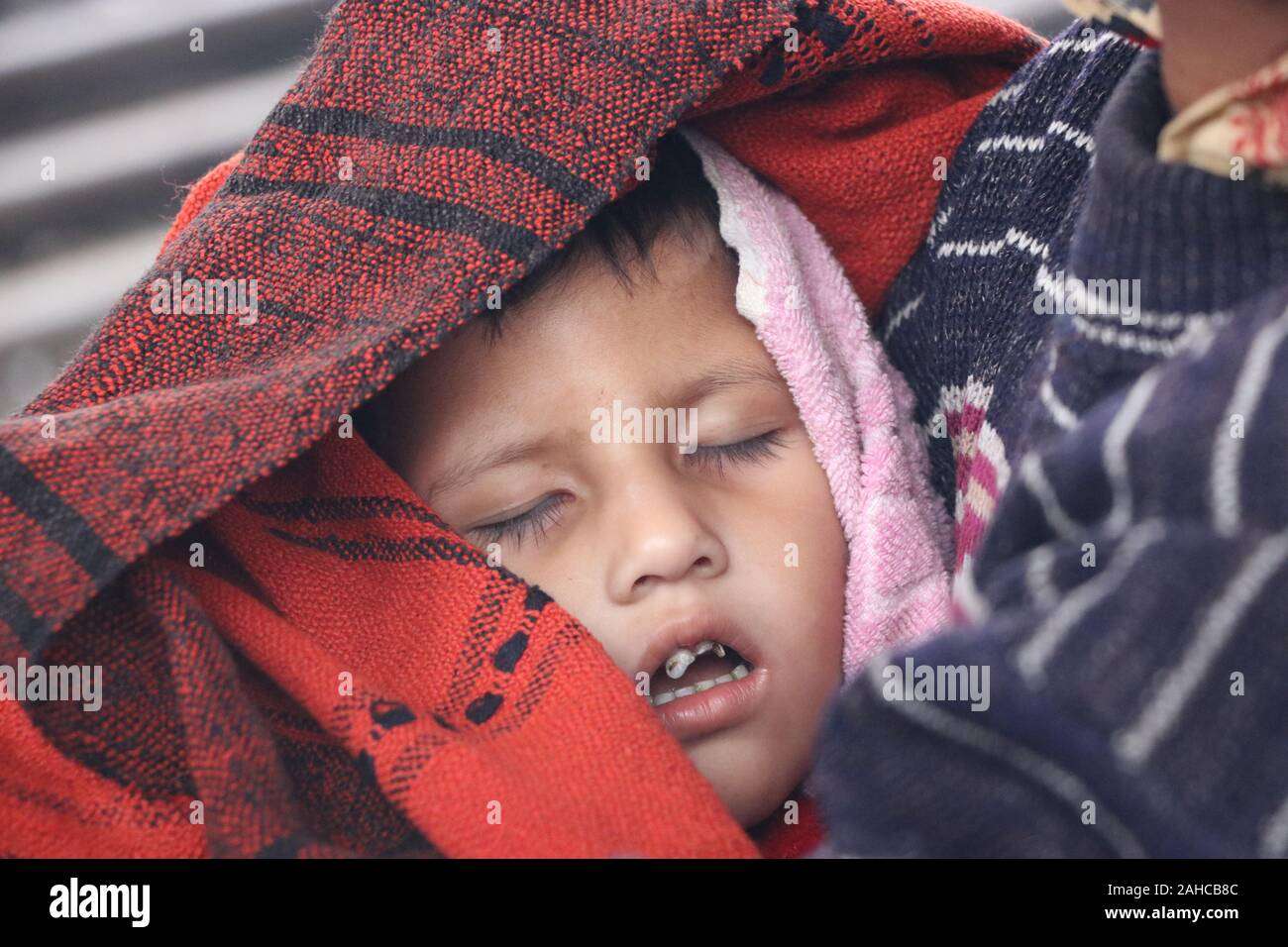 Inverno freddo tejgoan stazione ferroviaria, 21dec2019 tejgoan ferrovia stationDhaka Bangladesh.an donna anziana tiene il bambino in braccio e avvolge il bambino con un foglio per proteggerlo dal freddo.Nazmul Islam / alamy Stock Live notizie Foto Stock