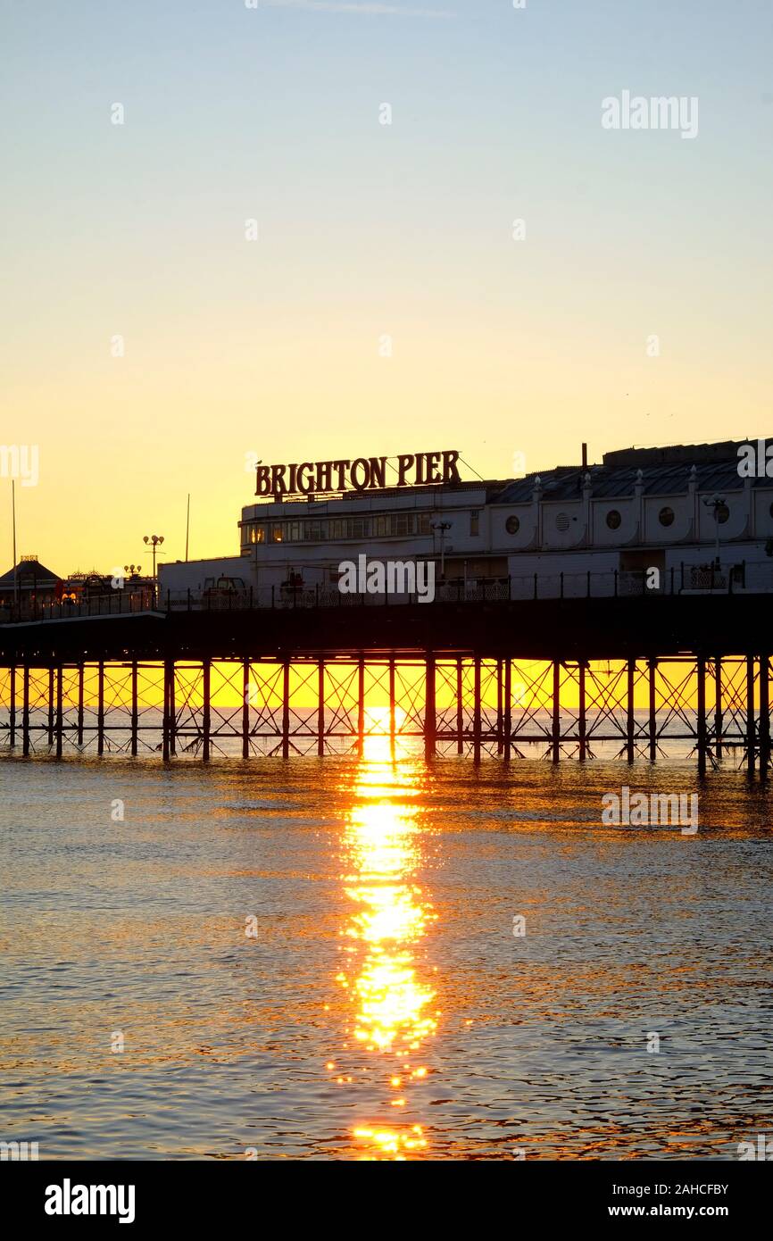 Brighton Palace Pier, la parte anteriore del molo con il nome su di esso, guardando dal mare, il sole tramonta sotto il molo formando una bella stella ef burst Foto Stock