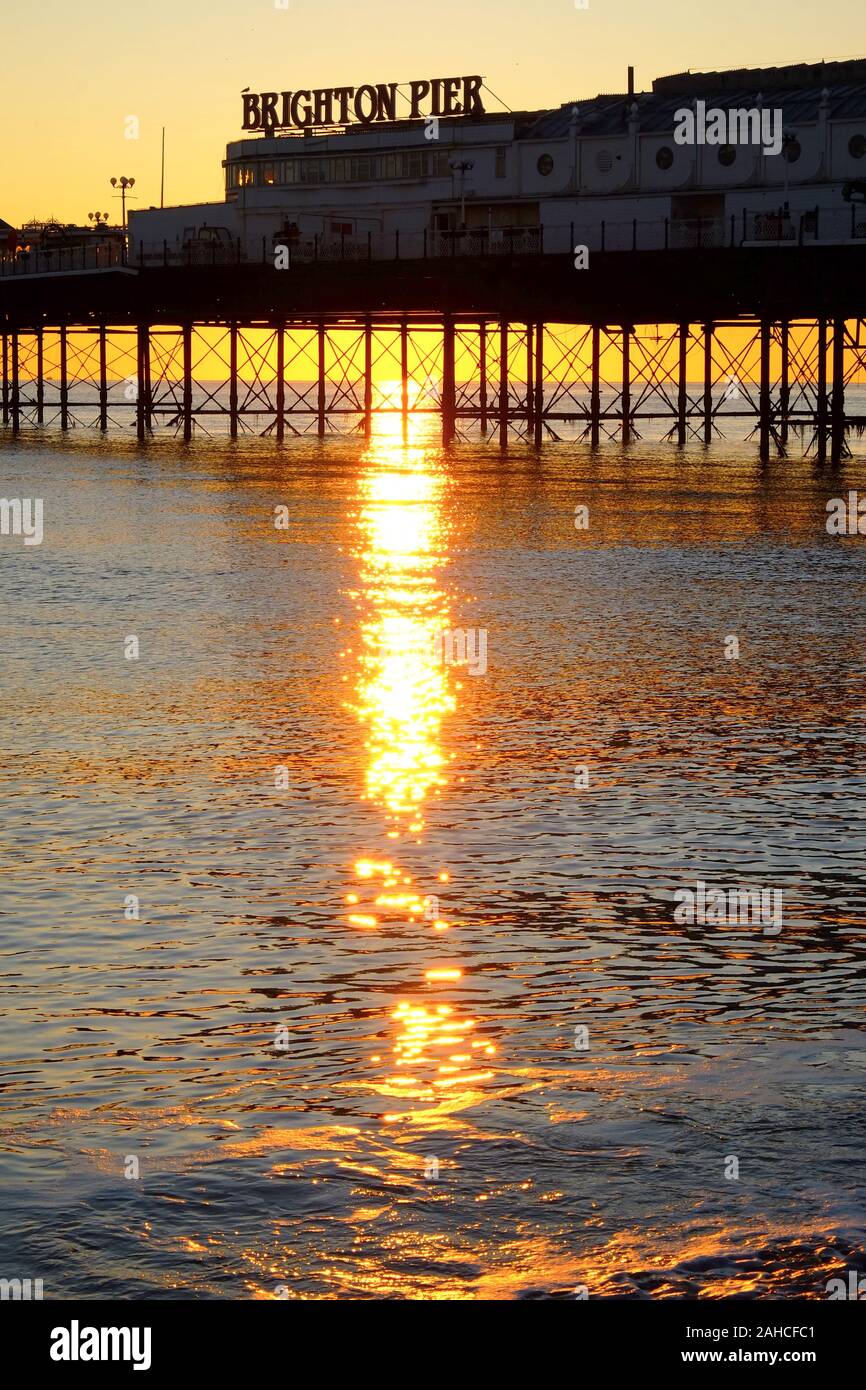 Brighton Palace Pier, la parte anteriore del molo con il nome su di esso, guardando dal mare, il sole tramonta sotto il molo formando una bella stella ef burst Foto Stock