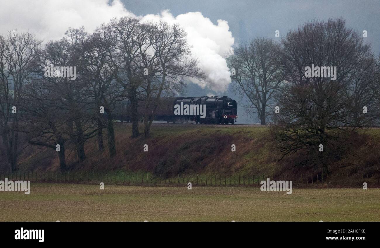 Locomotiva a vapore 92212, Ferrovie britanniche standard di classe 9F, rende il modo lungo la metà Hants railway, noto anche come la linea di crescione, tra Ropley e Medstead in Hampshire. Foto Stock