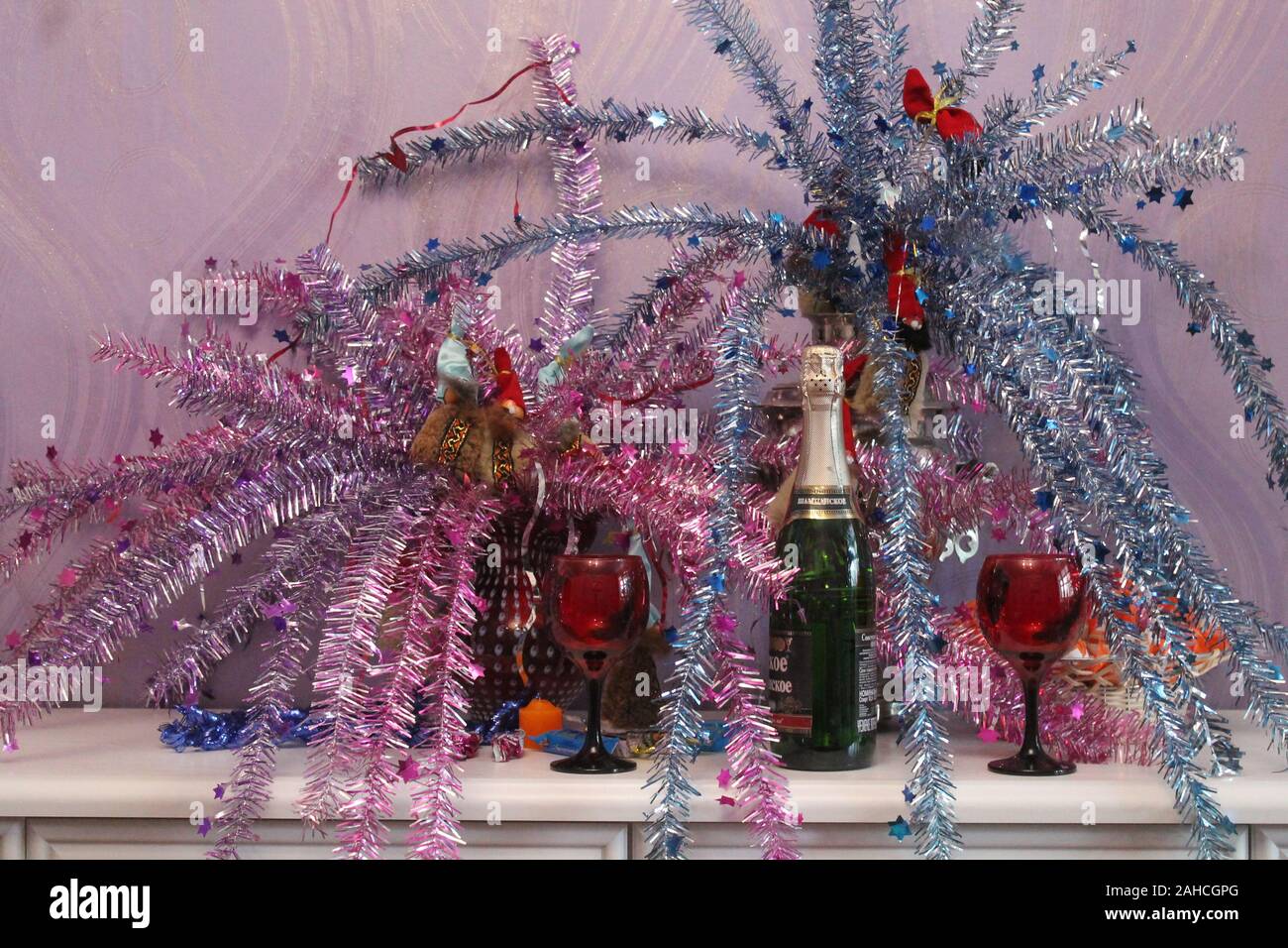 Bottiglia di champagne con due red wineglasses rimanere sulla tavola per festeggiare il nuovo anno e di Natale Foto Stock