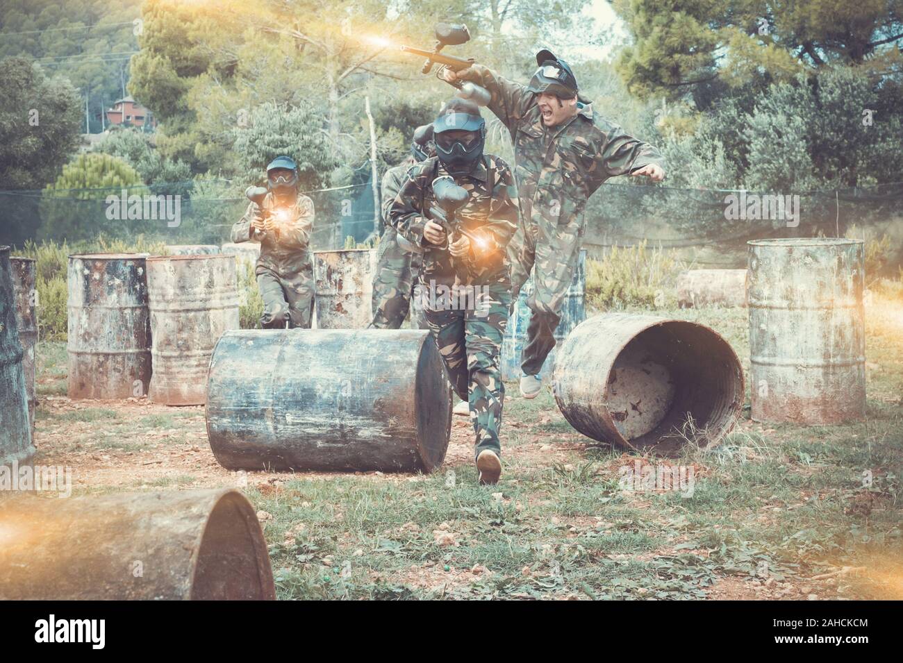 Dynamic paintball battaglia all'esterno. Gruppo di giocatori in camuffamento attaccando squadra opposta Foto Stock