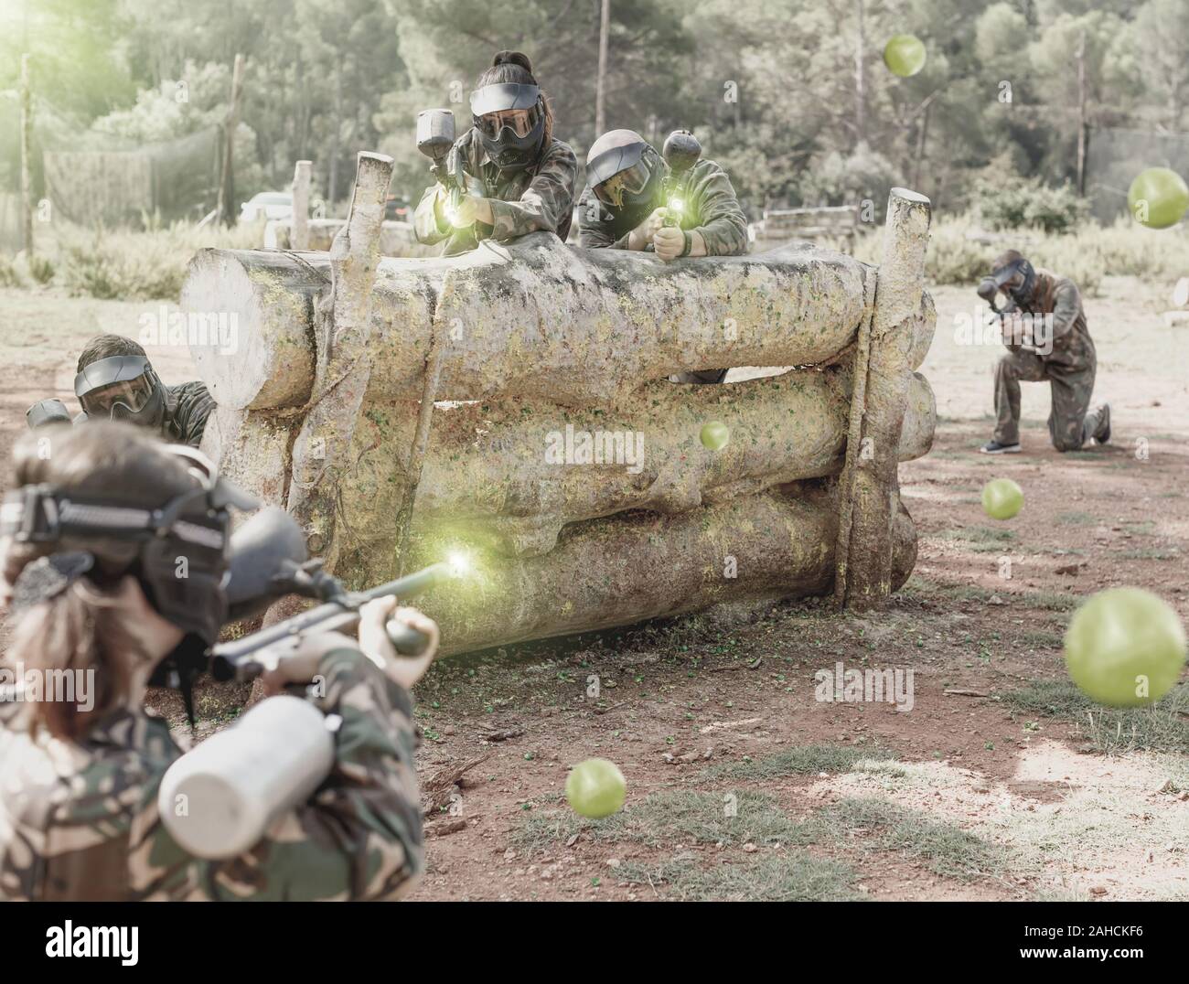 Gruppo di persone a paintball giocatori in camuffamento di suonare insieme in battaglia nella foresta all'aperto Foto Stock