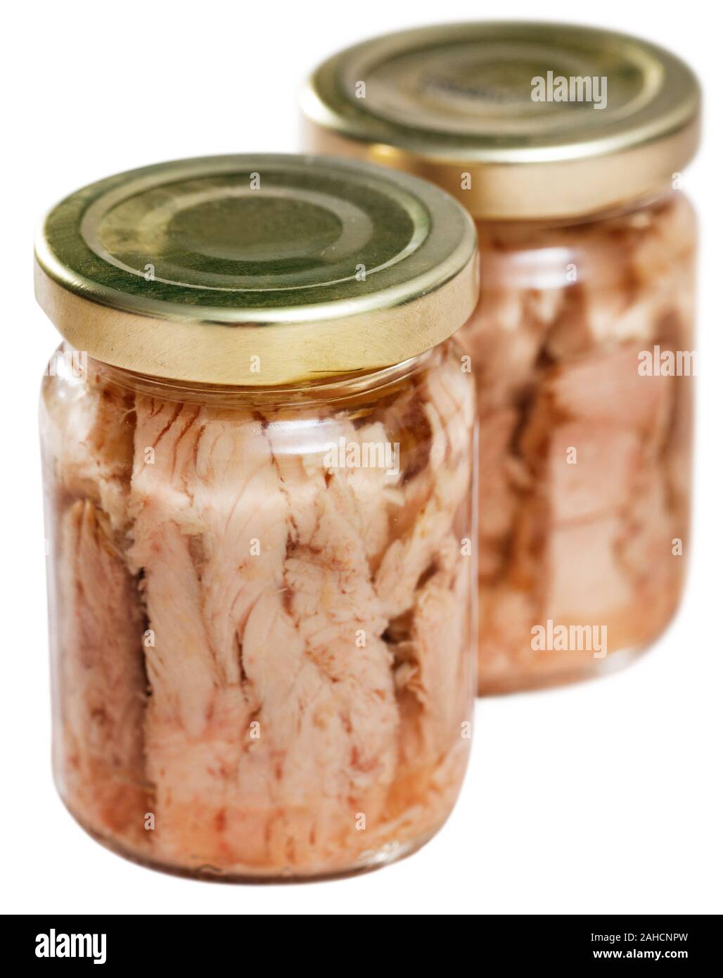 Appetitosi bonito naturale a filetti in olio in un barattolo di vetro. Isolato su sfondo bianco Foto Stock