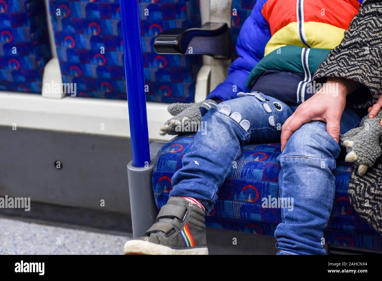 Madre e figlio viaggiare insieme su un treno lei è rassicurante il ragazzo come essi siedono Foto Stock