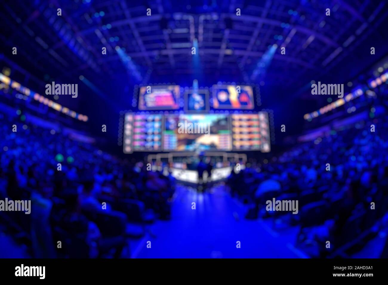 Sfocare lo sfondo di un evento di esports - Grande illuminato stadio principale di un computer games torneo situato su di un grande stadio. Il suo giro di tribune sono pieni di vide Foto Stock