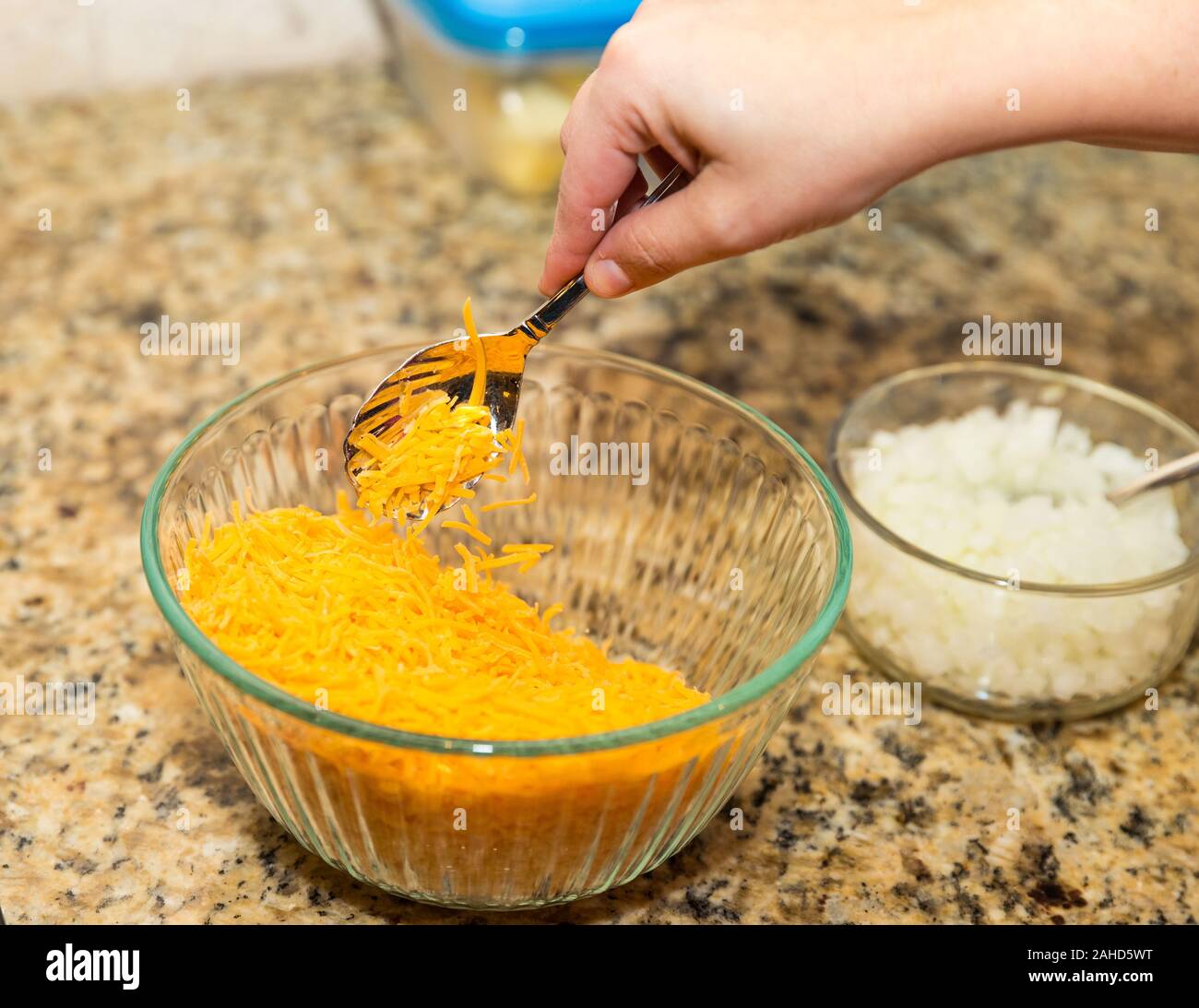 Sessole per mano di formaggio Cheddar grattugiato dalla ciotola Foto Stock