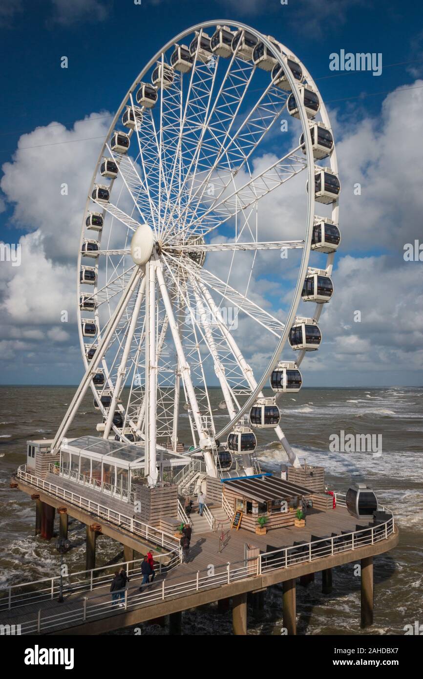 Un bianco ferries wheel presso il molo di Scheveningen con il mare del Nord in background Foto Stock