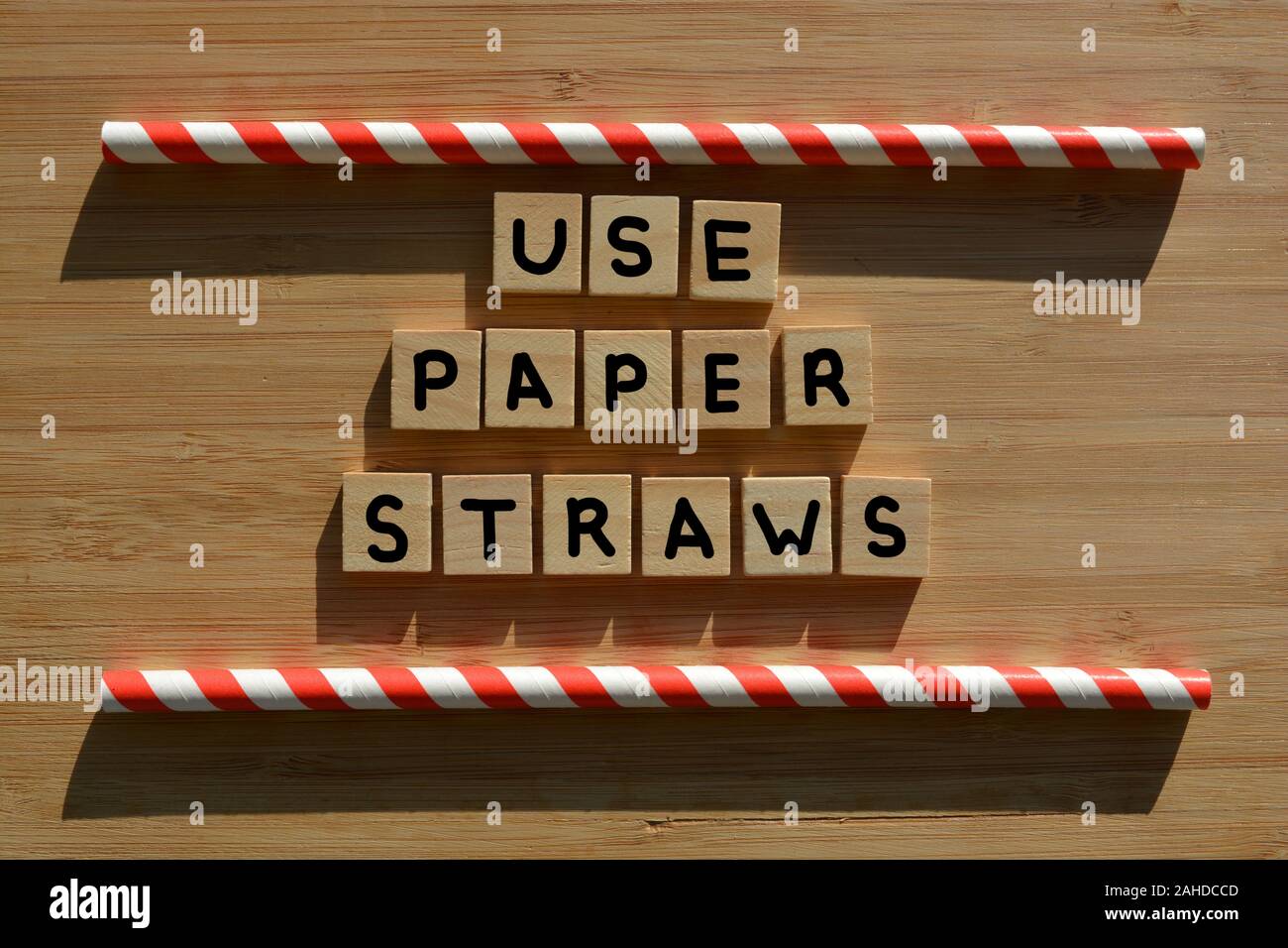 Utilizzare carta cannucce e parole in 3d alfabeto di legno lettere su fondo in legno con il rosso e bianco cannucce Foto Stock
