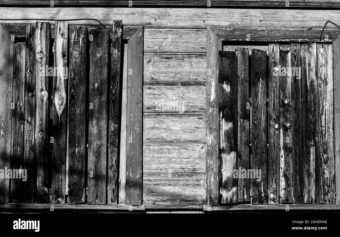 Immagine monocromatica di windows di abbandono di vecchia casa in legno martellato con assi Foto Stock