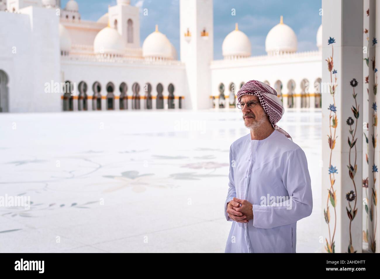 Uomo Arabo visitando la Grande Moschea di Abu Dhabi indossando kandora Foto Stock