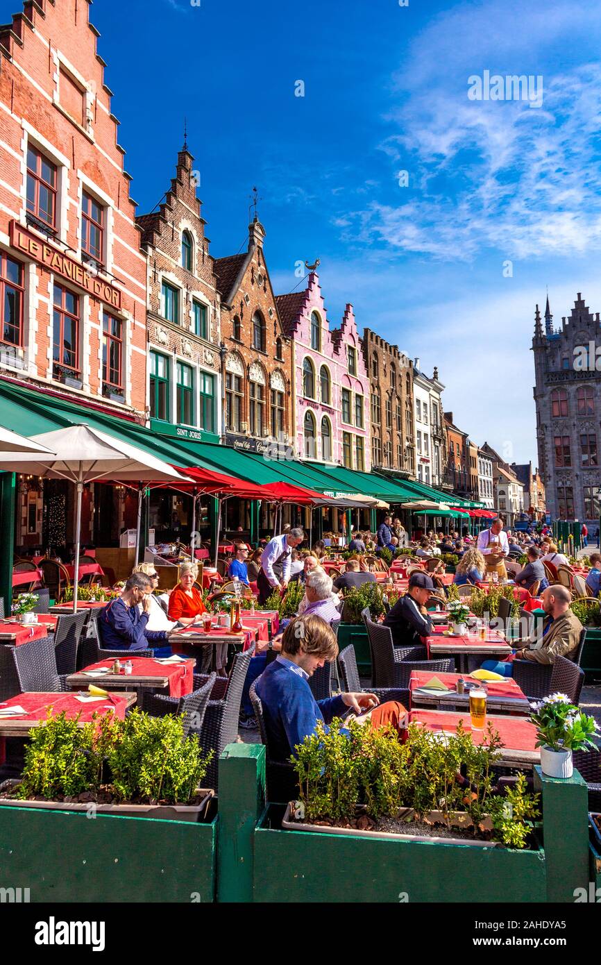 La gente seduta a al fresco e ristoranti intorno al Markt nel centro di Bruges, Belgio Foto Stock