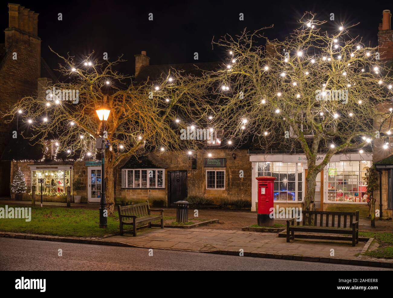 Le decorazioni di Natale lungo la high street a Broadway di notte. Broadway, Cotswolds, Worcestershire, Inghilterra Foto Stock