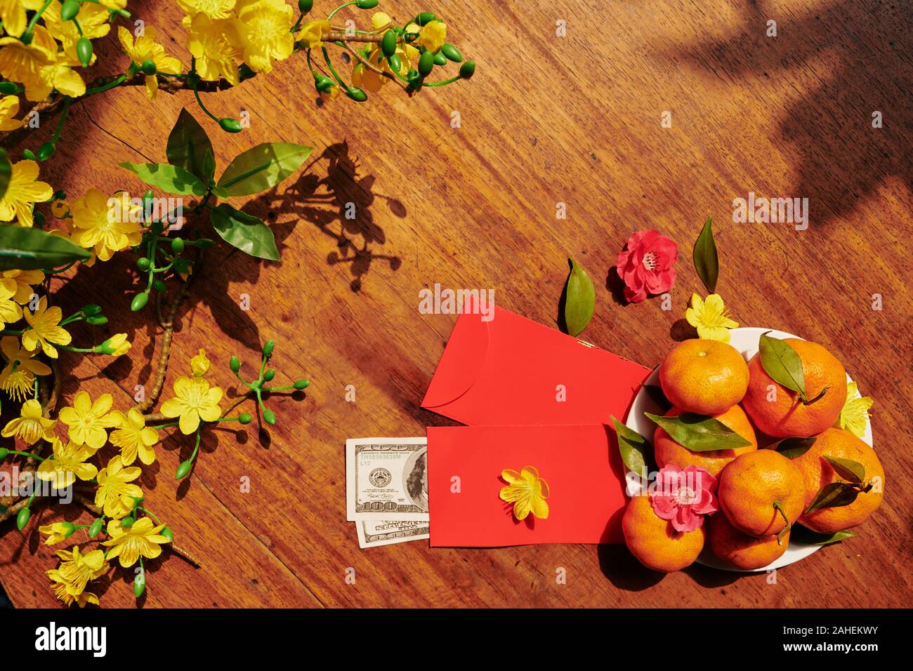 Rami di fioritura albero di albicocca e frutti e buste rosse con denaro repared per il nuovo anno lunare Foto Stock
