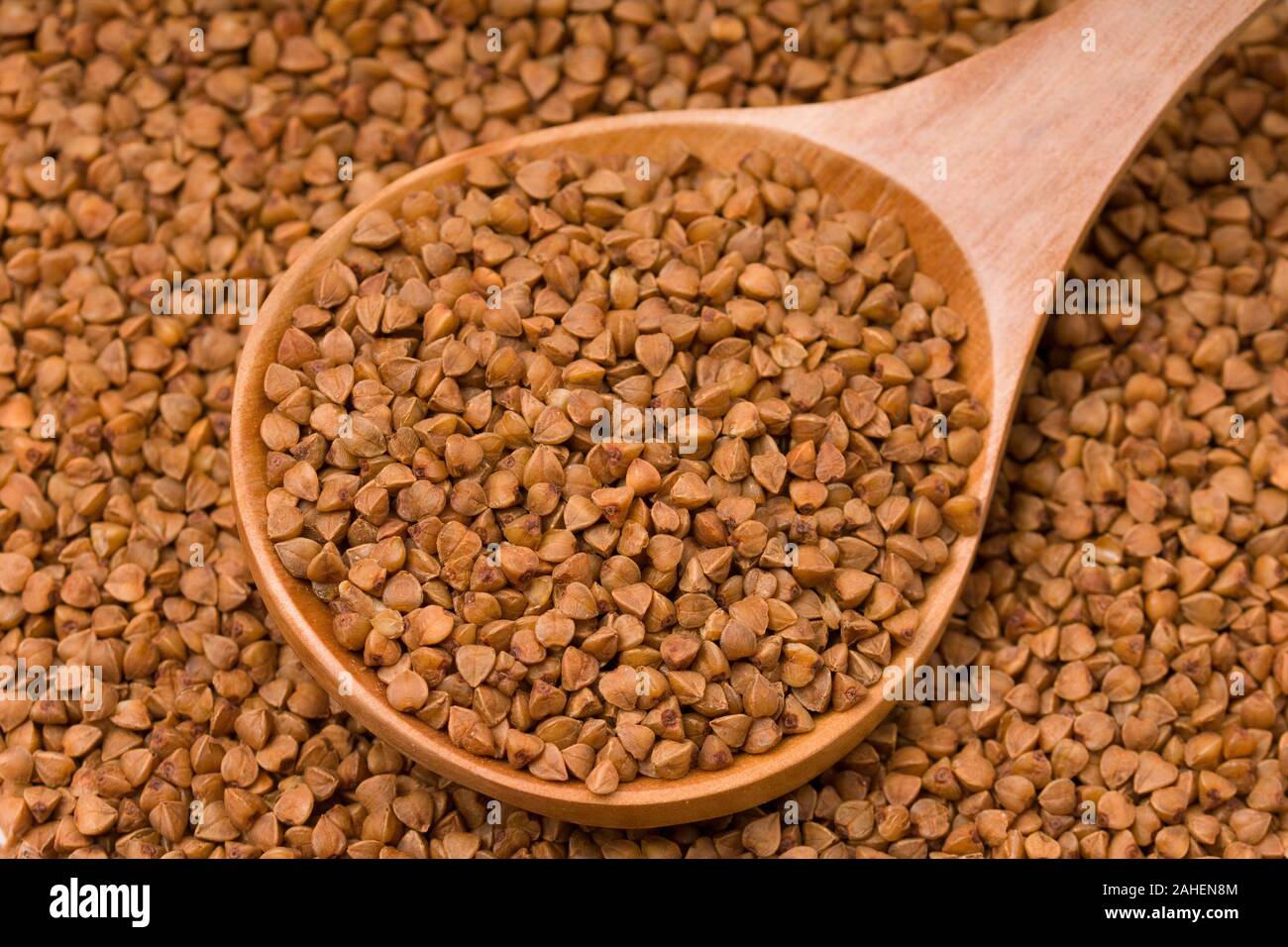 Materie del grano saraceno in un cucchiaio di legno. Uno stile di vita sano, dieta, perdita di peso, cibo sano concetto . close up Foto Stock