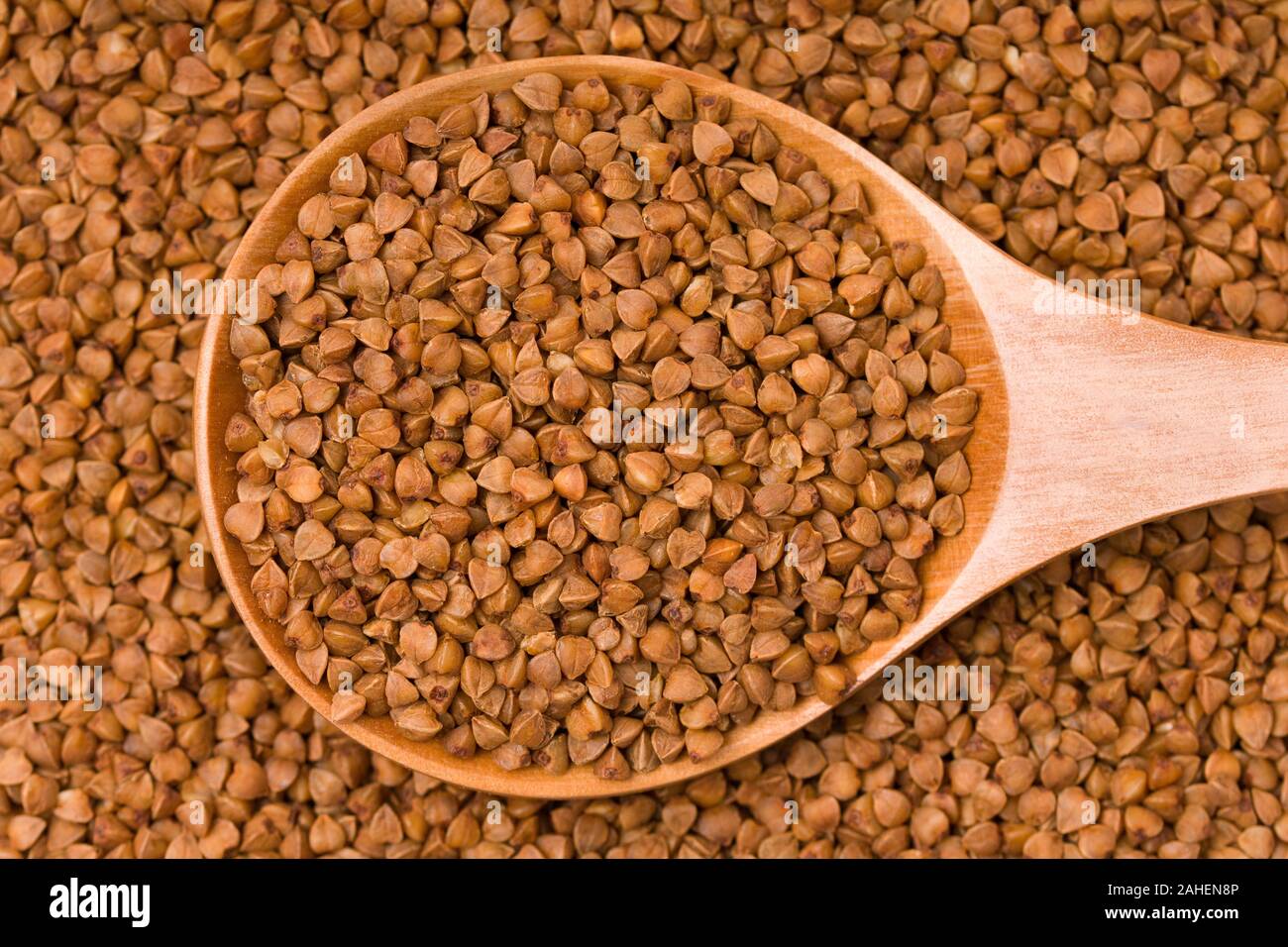 Materie del grano saraceno in un cucchiaio di legno. Uno stile di vita sano, dieta, perdita di peso, cibo sano concetto Foto Stock