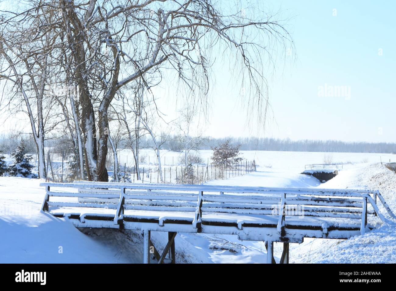 Ponte di legno nella neve. Idilliaco scenario rurale Foto Stock