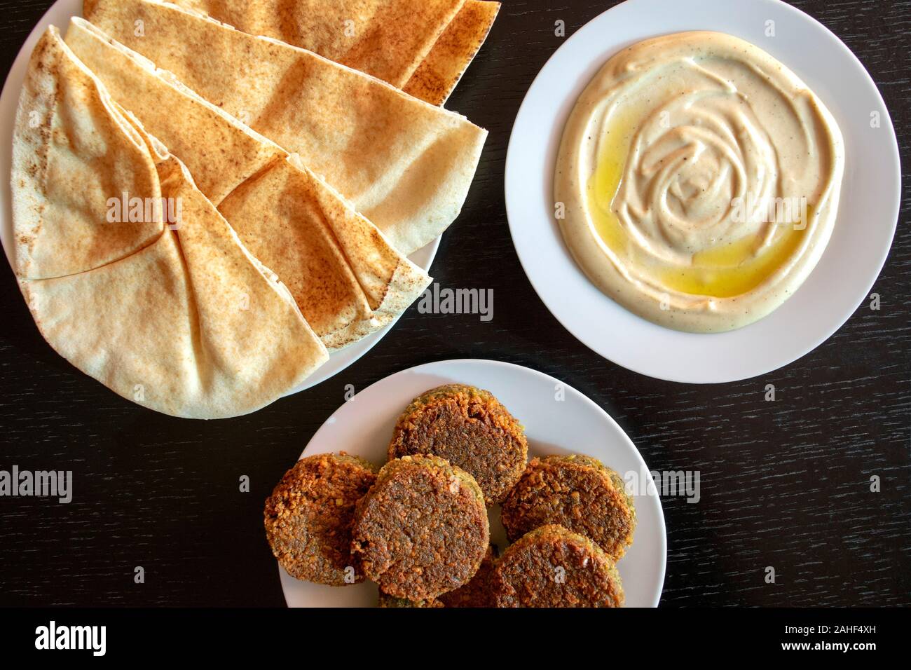 Famoso e tradizionale arabo, Medio Oriente, Israele cucina. Salsa tahini, pane pita e i falafel in legno scuro dello sfondo. Appartamento laico, vista dall'alto. Foto Stock