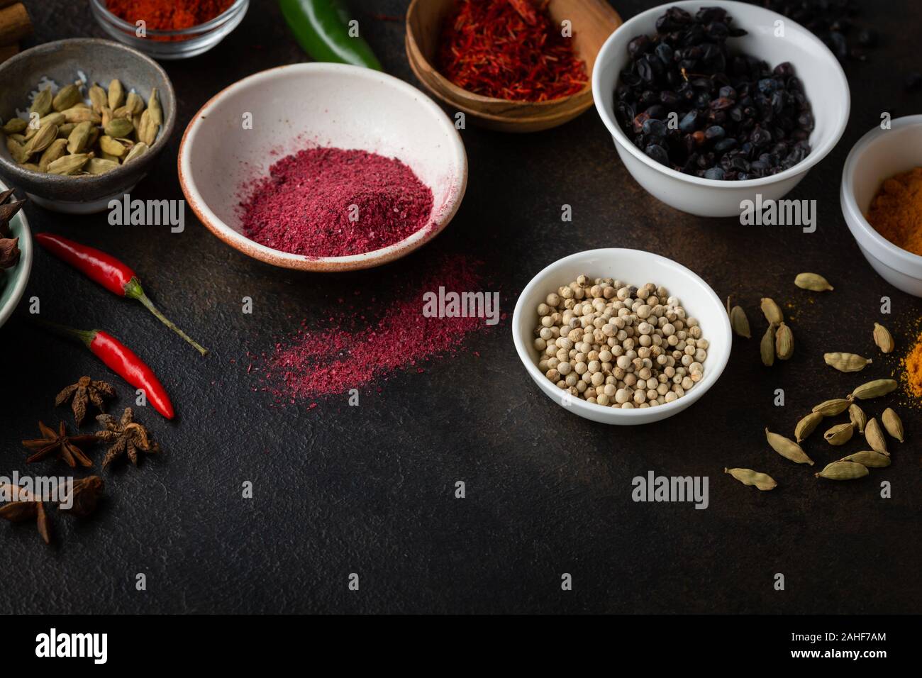 Tipi diversi di spezie e condimenti in un piccolo recipiente, ingredienti alimentari Foto Stock