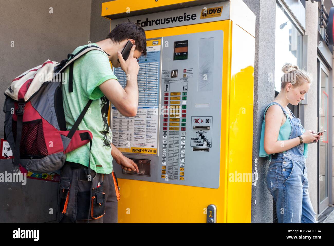 Giovane uomo acquistando i biglietti in un self-service di biglietteria macchina per le linee della città di Dresda Germania Foto Stock