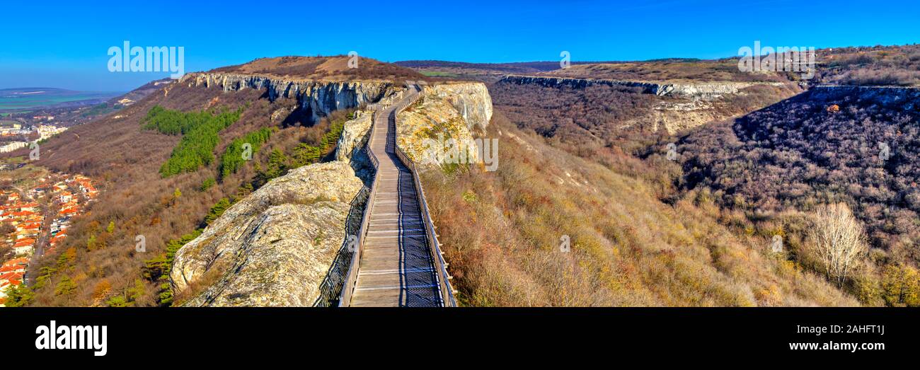 Bella vista con ponte di legno che conduce attraverso un paesaggio autunnale all'orizzonte Foto Stock