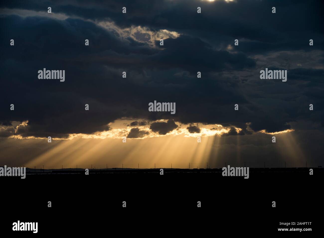 Raggi di luce solare penetrano nubi buie tempesta Foto Stock