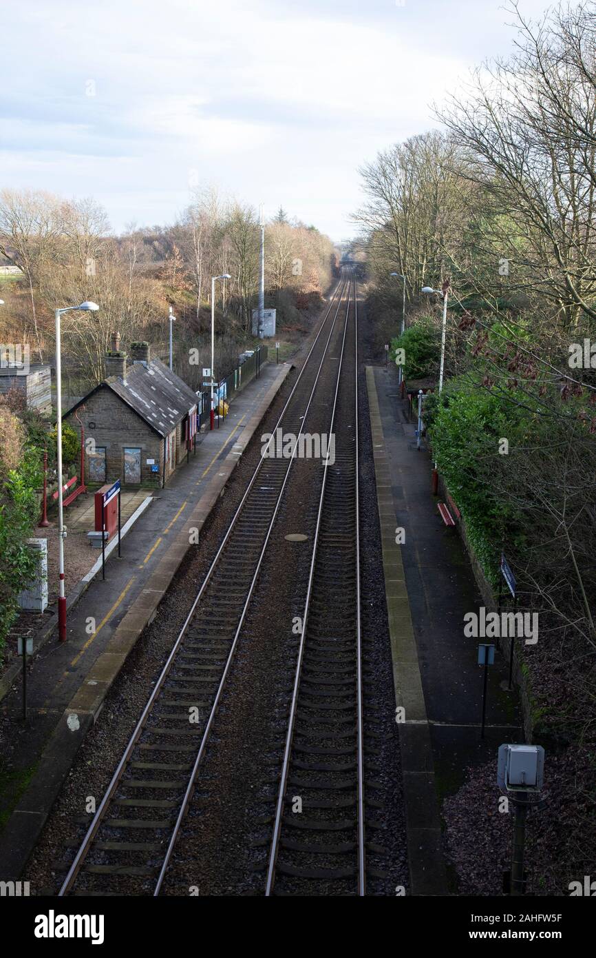 Stocksmoor Stazione ferroviaria dal ponte del paese che mostra i binari ferroviari che serve Huddersfield a Sheffield nello Yorkshire Foto Stock