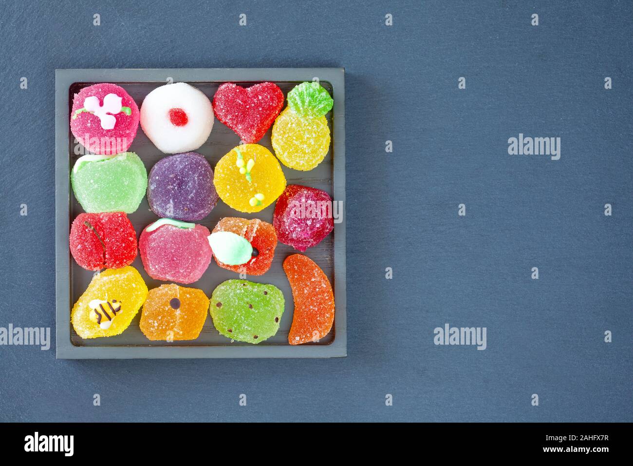 A forma di frutta gelatine in un vassoio quadrato, vista dall'alto (ardesia sfondo) Foto Stock