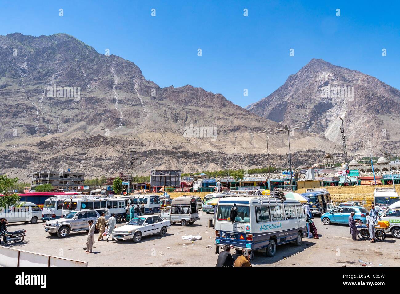 Gilgit a lunga distanza Intercity Bus Terminal con minibus in attesa di passeggeri su una soleggiata cielo blu giorno Foto Stock