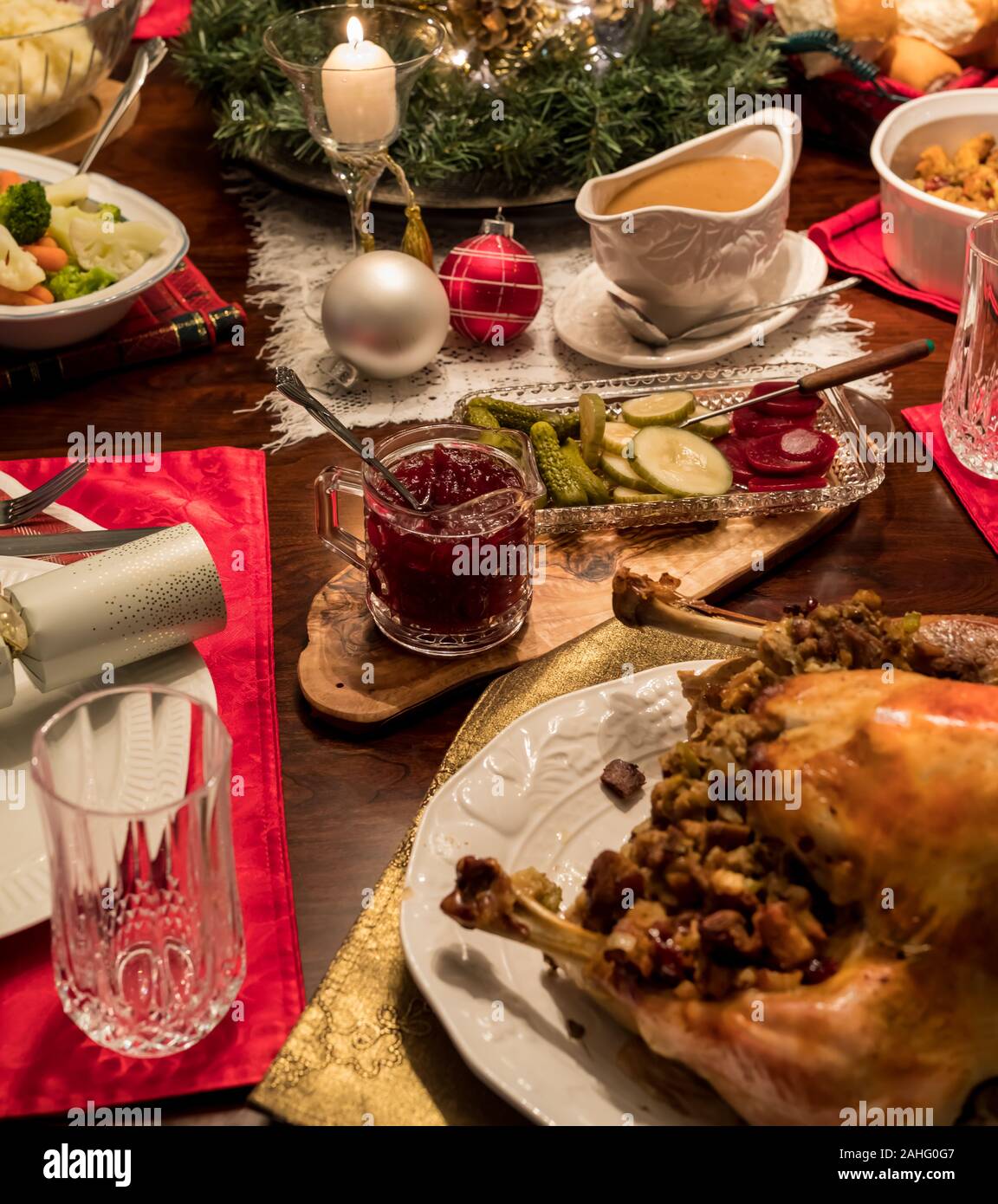 Una chiusura di un tavolo da pranzo vestito con un completo tacchino di Natale la cena inclusa salsa di mirtilli e sugo pronto per mangiare. Foto Stock