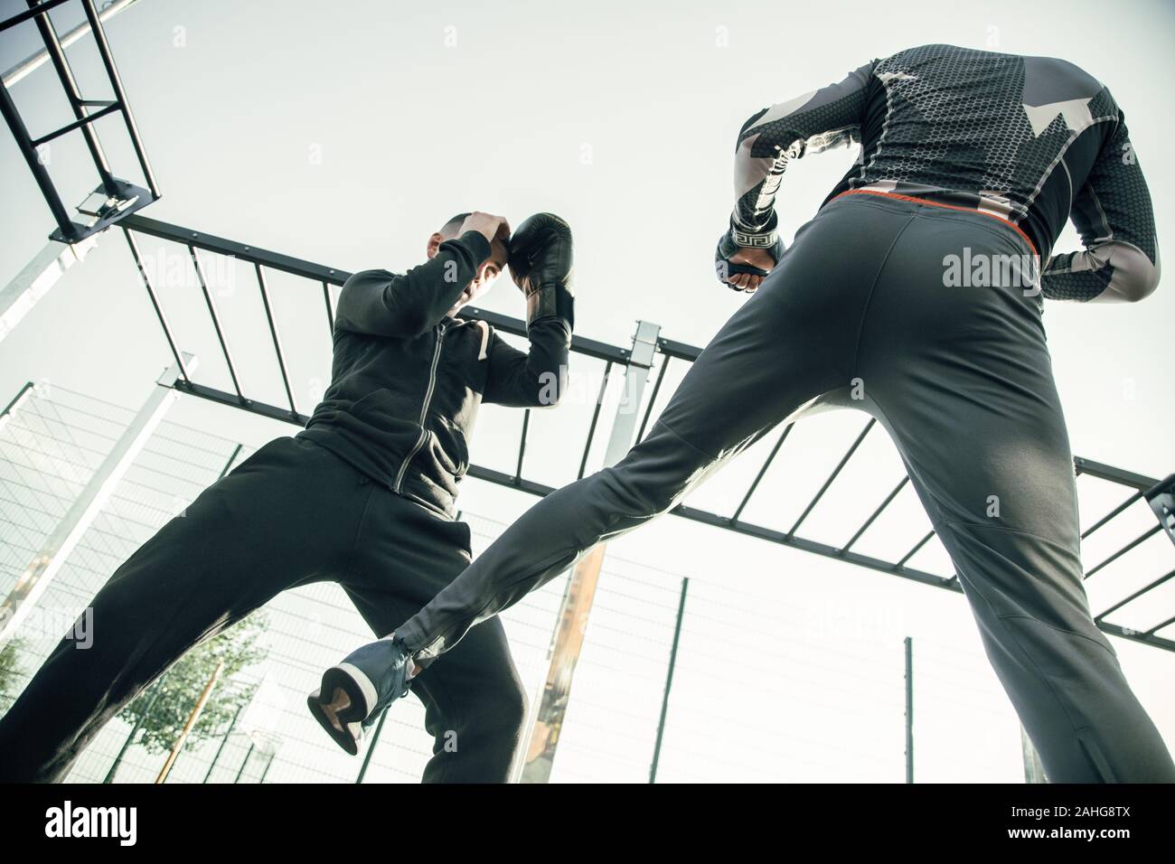 MMA boxer nascondendo la sua testa avendo al contempo la formazione con partner sportivi Foto Stock