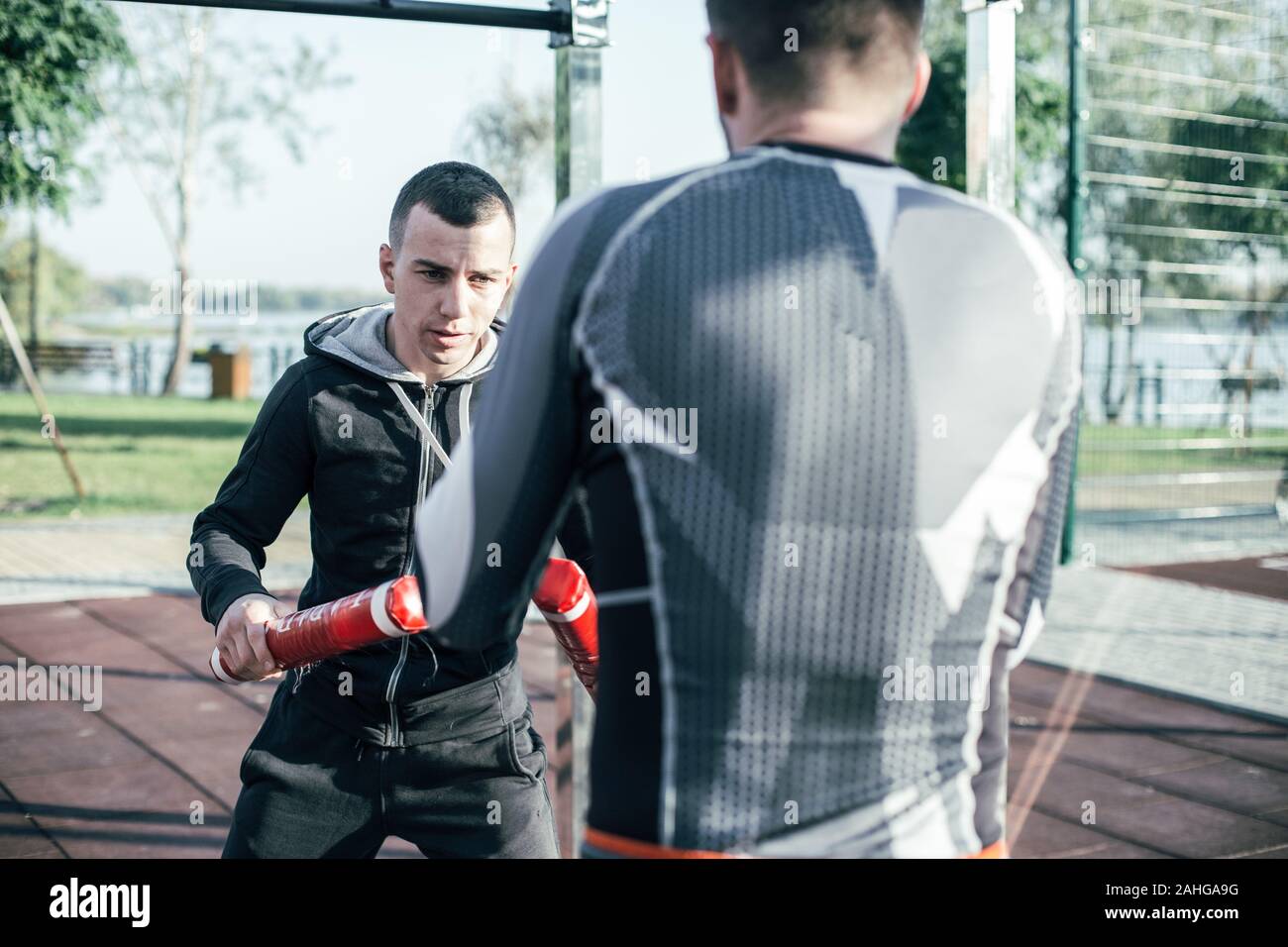 Attenzione trainer eseguendo la posizione e il boxer guardando lui Foto Stock