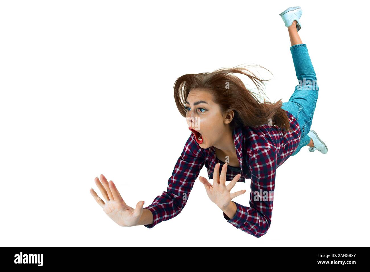 Un secondo prima di cadere. Caucasian ragazza giovane cada nel momento in cui con brillanti emozioni ed espressioni facciali. Modello femminile in abiti casual. Sconvolto, spaventata, urlando. Copyspace per annuncio. Foto Stock