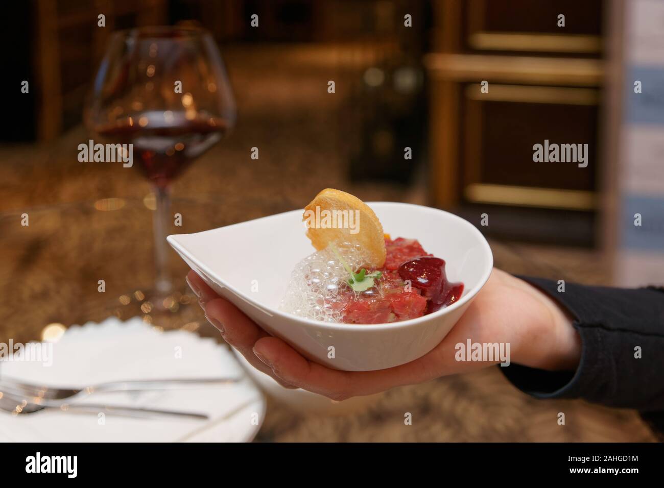 Donna che offre la tartare di manzo con spuma al banchetto permanente Foto Stock