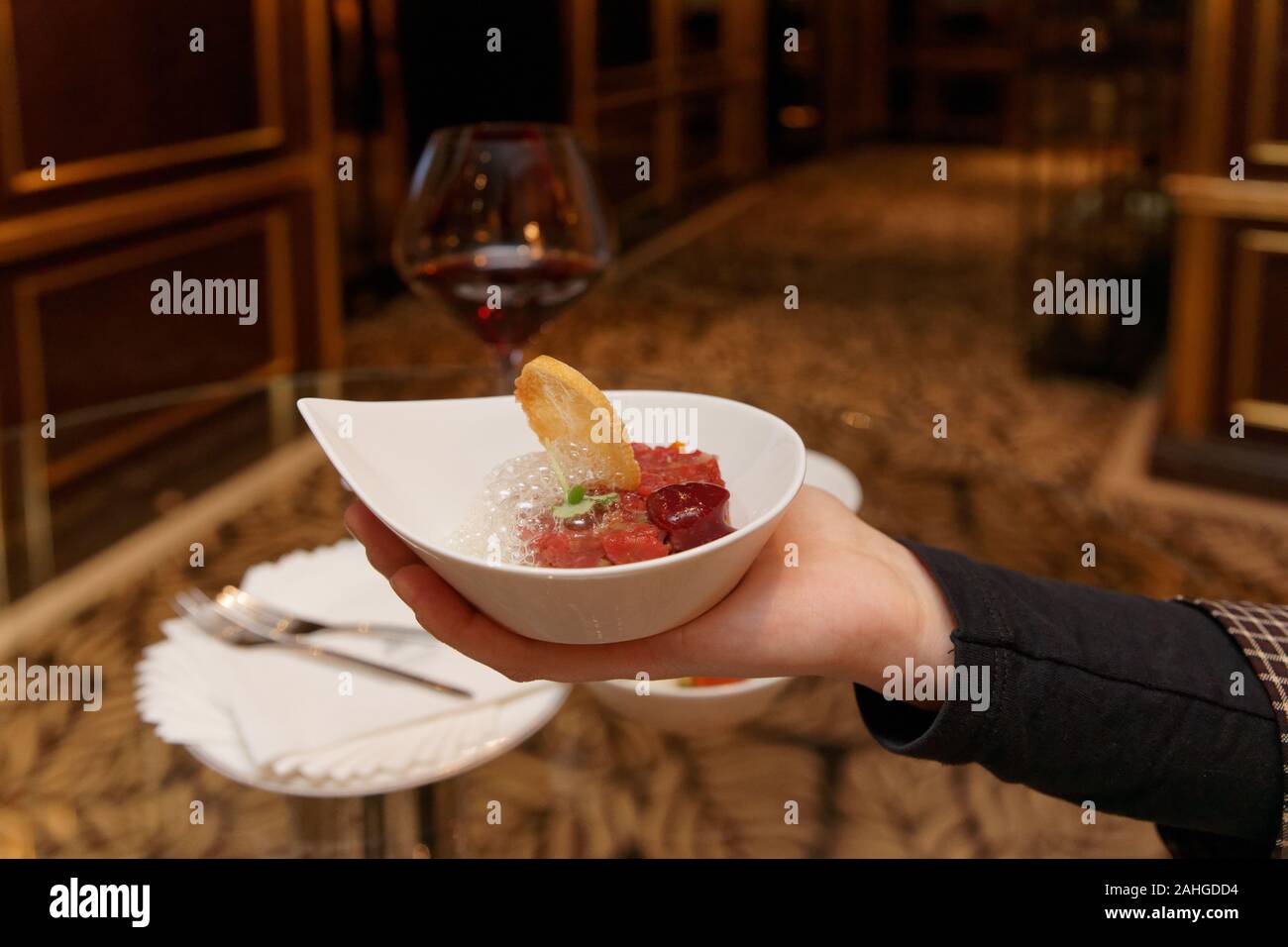 Donna che offre la tartare di manzo con schiuma molecolare Foto Stock