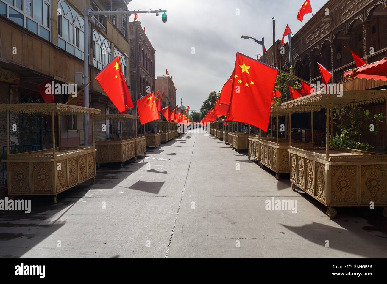 Street con le bancarelle del mercato nella Città Vecchia di Kashgar, Cinese bandiere su ogni stand: un segno della Chinese National Holiday (provincia dello Xinjiang, Cina) Foto Stock