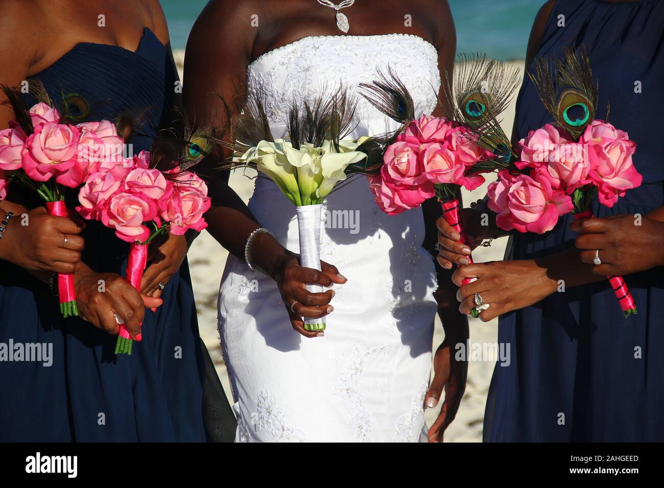 African American sposa su abito bianco insieme con bridesmaids che tiene bouquet di fiori colorati in giornata di nozze all'aperto. Dettaglio sulla cerimonia glamour Foto Stock
