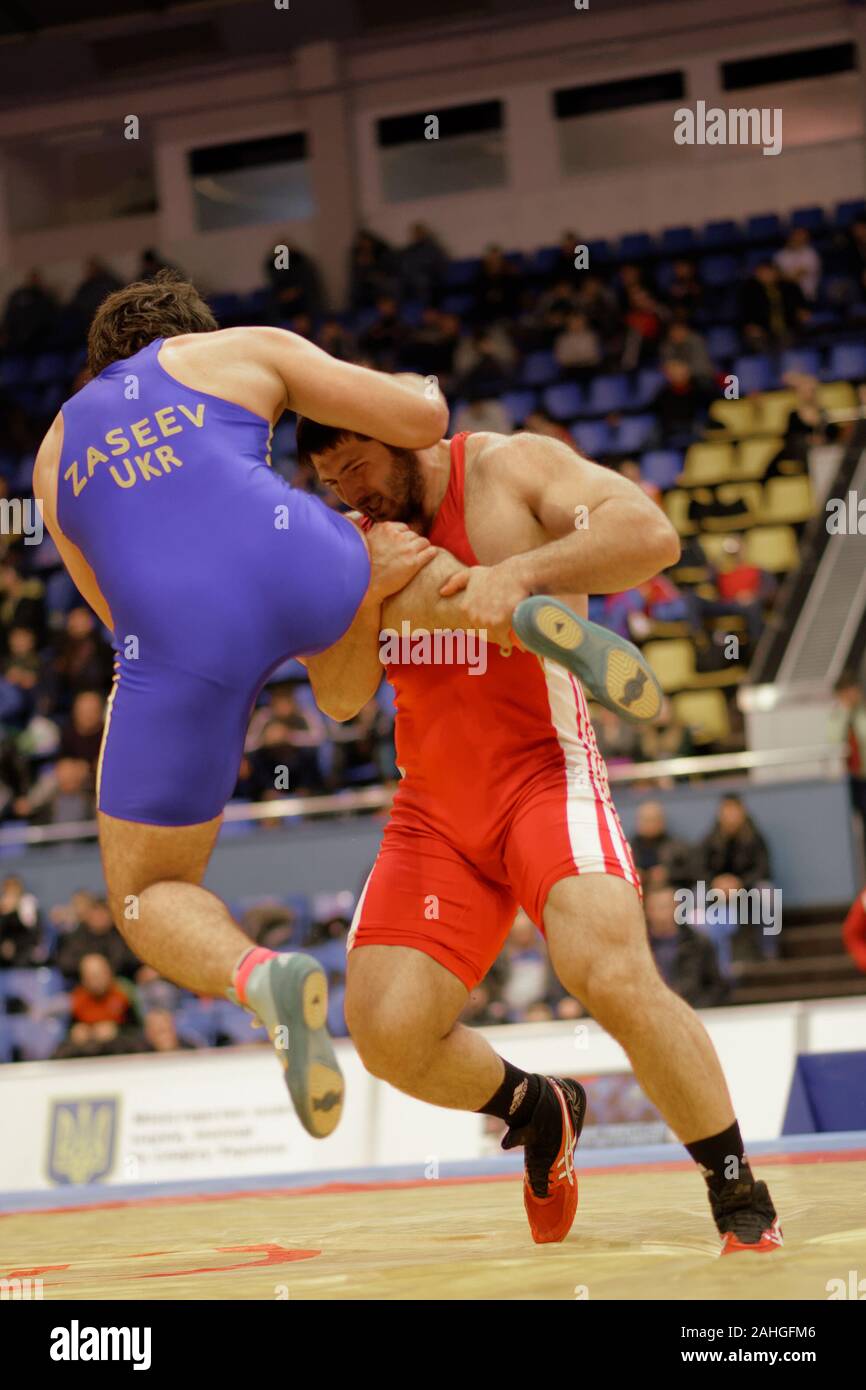 Kiev, Ucraina - 16 Febbraio 2013: Lotta Alen Zaseev, Ucraina, blu vs Modzmanashvili Gruetta, Georgia durante il XIX International freestyle wrestling e femmina torneo di wrestling Foto Stock